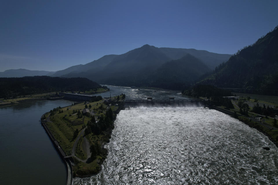 El agua pasa sobre la represa de Bonneville Dam en el río Columbia, que marca la línea entre los estados de Washington y Oregon, el martes 21 de junio de 2022. Las represas hidroeléctricas en el río Columbia y sus afluentes han reducido el flujo del río, lo que ha puesto en mayor peligro la migración del salmón río arriba desde el Pacífico hasta sus áreas de desove de agua dulce. (AP Foto/Jessie Wardarski)