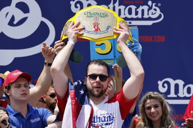 Patrick Bertoletti holds up the championship belt after winning the 108th Nathan's Hot Dog Eating Contest in Coney Island, Brooklyn, N.Y., on Thursday. Bertoletti swallowed 58 hot dogs in 10 minutes to be crowned the new champion in the absence of Joey Chestnut. Photo by Peter Foley/UPI