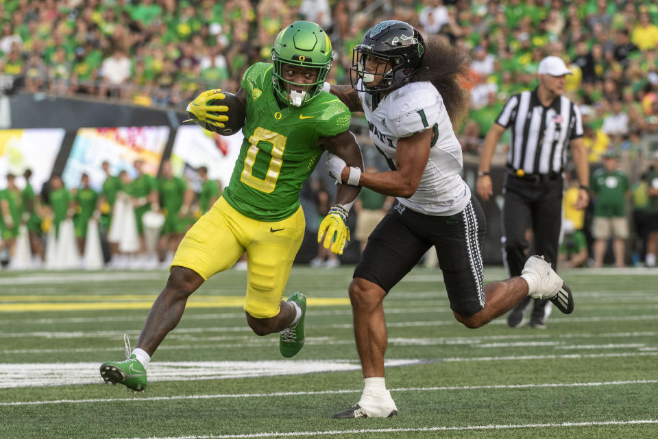 Oregon running back Bucky Irving (0) tries to avoid the tackle of Hawaii defensive back Peter Manuma (1) during the first half of an NCAA college football game Saturday, Sept. 16, 2023, in Eugene, Ore. (AP Photo/Andy Nelson)