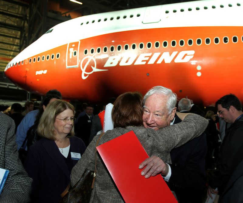 FILE PHOTO: Joe Sutter, Boeing's chief engineer on the original jumbo, hugs a woman in front of a newly unveiled 747-8 jumbo passenger jet in Everett