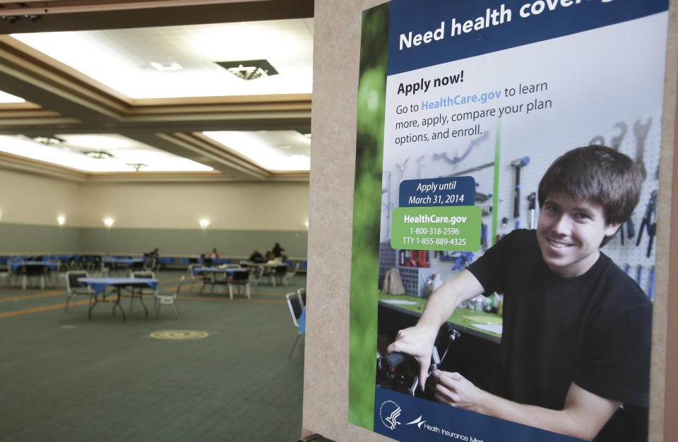 A poster touting health insurance hangs on a door to a nearly empty room at a convention center in Texas City, Texas, Saturday, March 1, 2014. Though organizers had recruited assisters to handle as many as 400 people seeking help in navigating the federal insurance marketplace, only a handful had come by in the first hours of operations. (AP Photo/Pat Sullivan)