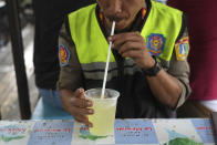 A municipal worker sips a sweetened beverage in Jakarta, Indonesia Tuesday, Oct. 24, 2023. Indonesia — the biggest sugar importer last year, according to the United States Department of Agriculture — has cut back on imports. (AP Photo/Tatan Syuflana)