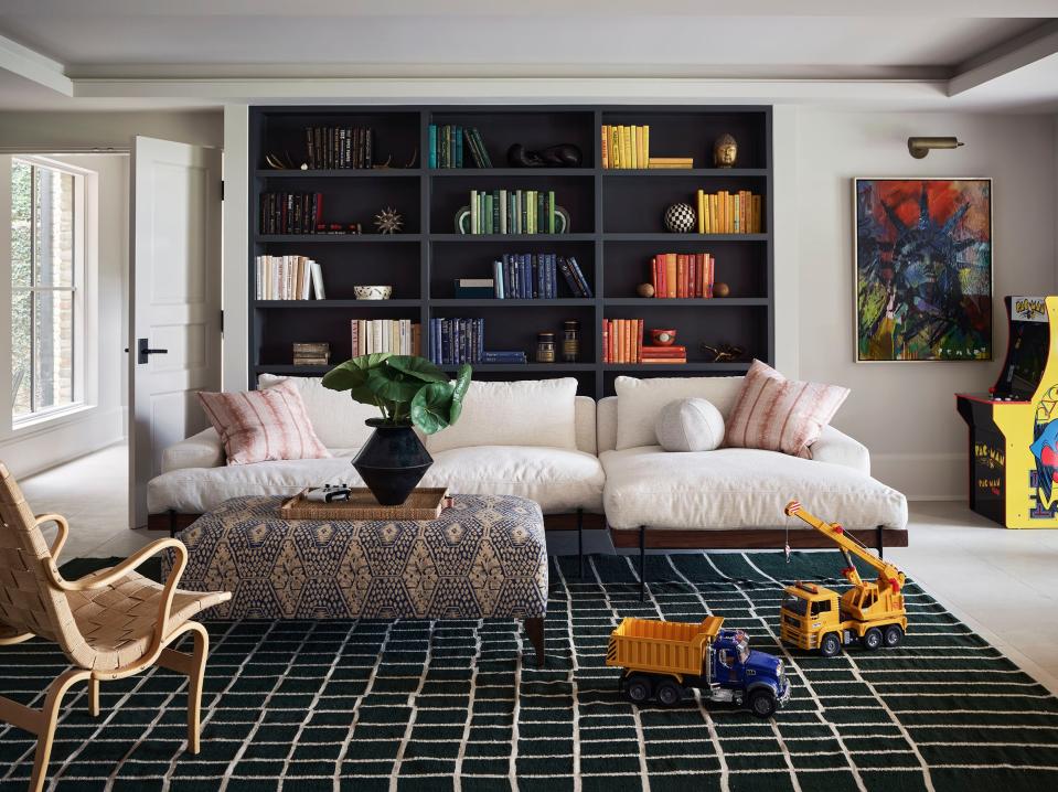 “The ceilings were seven feet tall and oppressive,” says Seiders of the basement. “We painted everything nice and bright, and decided the whole downstairs was going to be just for the kids.” The sectional sofa, from Croft House, was paired with an ottoman upholstered in Jennifer Shorto’s Leo fabric.