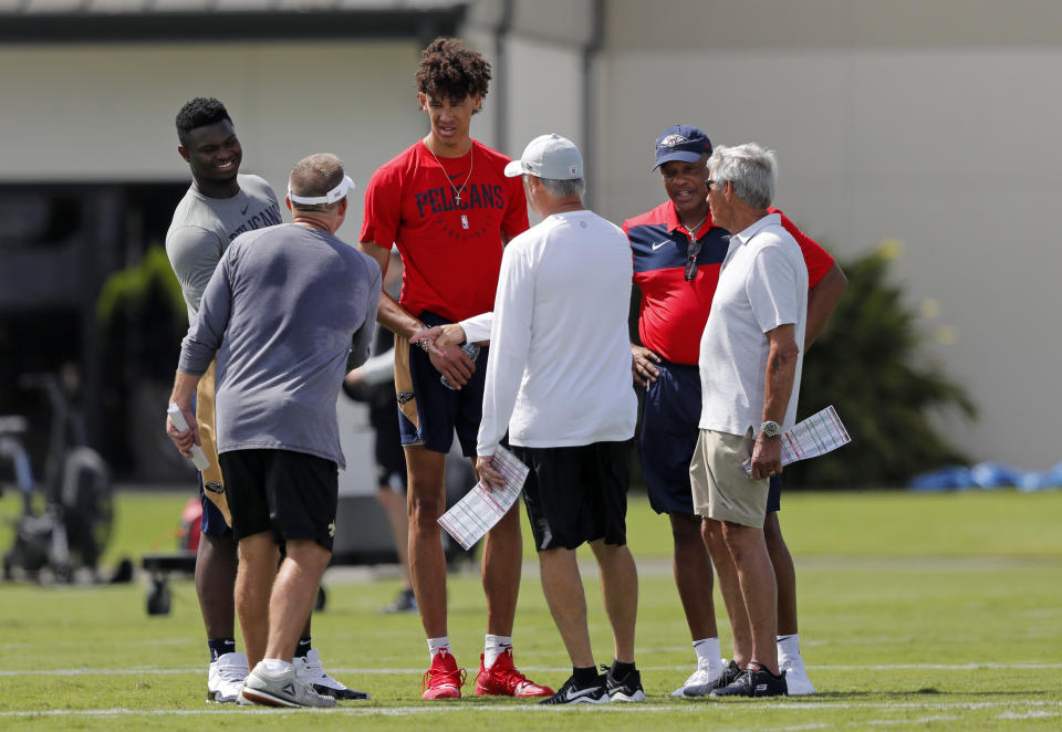 New Orleans Saints head coach Sean Payton, left with back facing camera, greets NBA basketball New Orleans Pelicans draft picks Zion Williamson, left, Jaxson Hayes, center, and head coach Alvin Gentry during training camp at their NFL football training facility in Metairie, La., Friday, July 26, 2019. With them are Saints general manager Mickey Loomis, center with back to camera, and former Saints head coach Jim Mora, right. (AP Photo/Gerald Herbert)