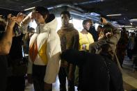 Models get ready in the backstage prior to the start of the K-Way men's Fall-Winter 2022-23 fashion show, unveiled during the Fashion Week in Milan, Italy, Monday, Jan. 17, 2022. (AP Photo/Antonio Calanni)