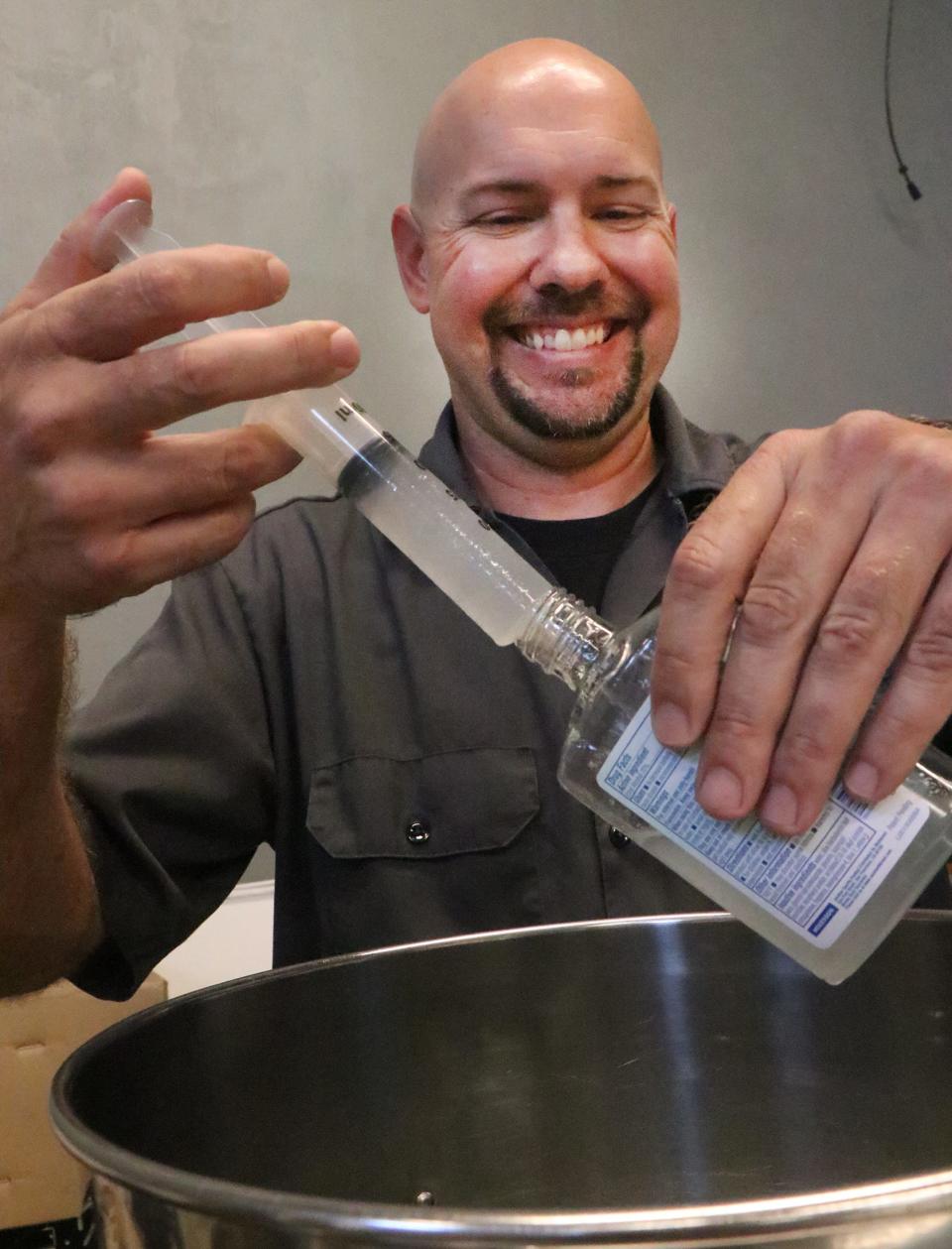 Copper Bottom Craft Distillery owner Jeremy Craig, laughs while he fills small bottles with hand sanitizer, Wednesday March 18, 2020 as the Holly Hill, Florida, distillers use some of their product to make hand sanitizer and give it away to those in the community during the Coronavirus outbreak.