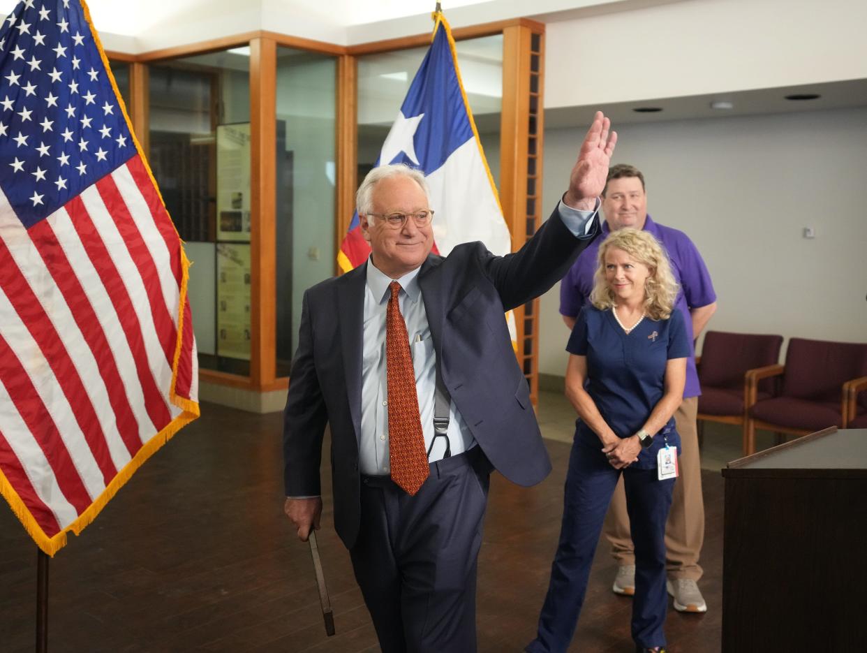 Austin Mayor Kirk Watson waves after speaking at a news conference Tuesday at the William P. Hobby Jr. State Office Building. Plans were announced to redevelop the building's site to include workforce housing.