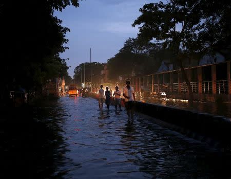 People wade through a flooded road in Chennai, India, December 3, 2015. REUTERS/Anindito Mukherjee