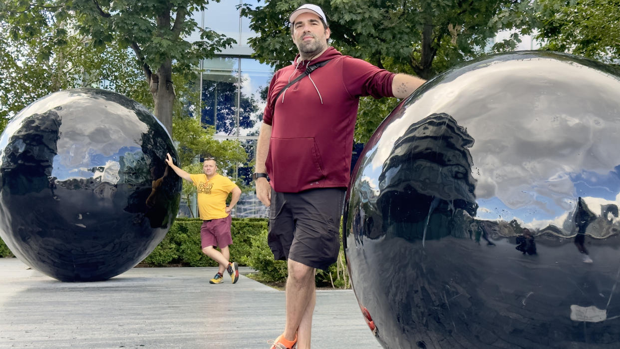  Man standing next to large ball. 