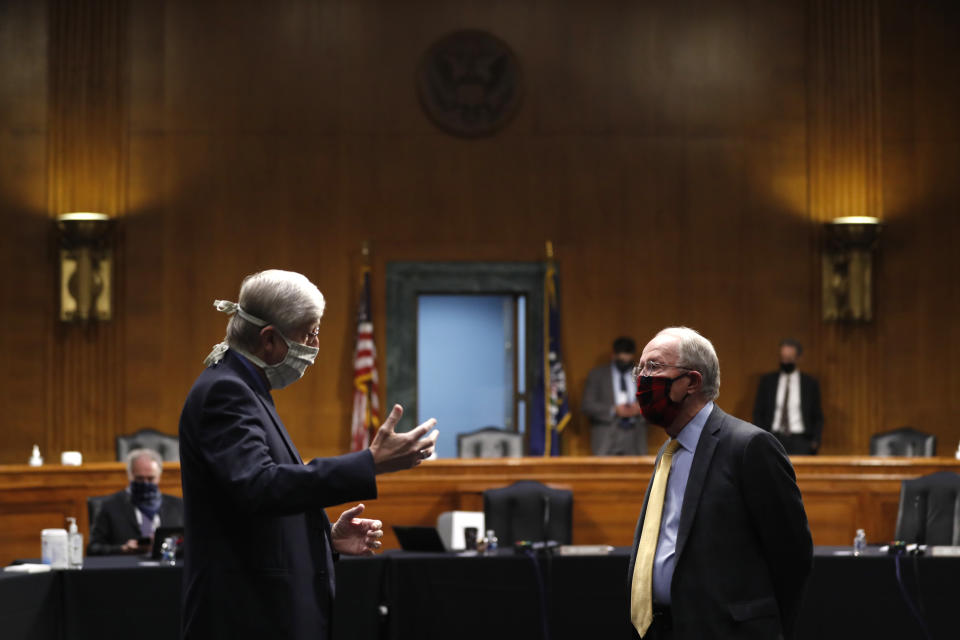 FILE - In this Thursday, May 7, 2020 file photo, National Institutes of Health Director Dr. Francis Collins, left, speaks with Chairman Sen. Lamar Alexander, R-Tenn., prior to a Senate Health Education Labor and Pensions Committee hearing on new coronavirus tests on Capitol Hill in Washington. Collins has lauded the majority of American faith communities for treating the pandemic as an opportunity to live out their values by helping the vulnerable. He also offered careful criticism for the “occasional examples of churches who reject the scientific conclusions and demand the right to continue to assemble freely, even in the face of evidence that this endangers their whole community.”(AP Photo/Andrew Harnik, Pool)