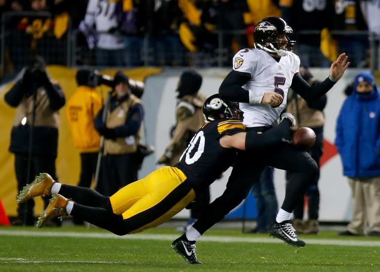 Joe Flacco of the Baltimore Ravens fumbles as he is sacked by T.J. Watt of the Pittsburgh Steelers in the fourth quarter at Heinz Field