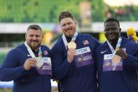 Gold medalist Ryan Crouser, of the United States, center, stands on the podium with silver medalist Joe Kovacs, of the United States, left, and bronze medalist Josh Awotunde, of the United States, during a medal ceremony for the men's shot put final at the World Athletics Championships on Sunday, July 17, 2022, in Eugene, Ore. (AP Photo/David J. Phillip)