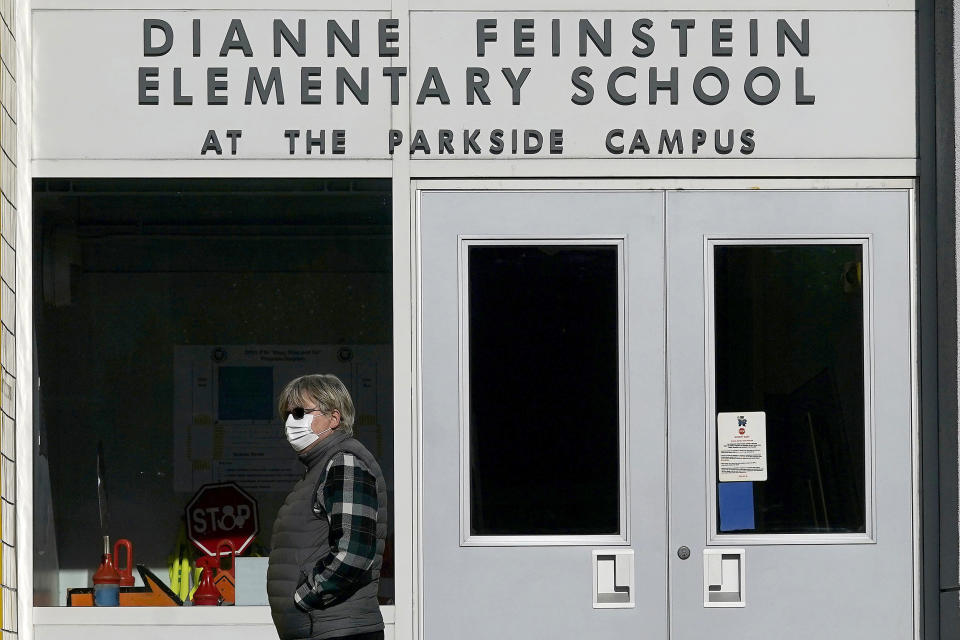 Image: A pedestrian walks below a sign for Dianne Feinstein Elementary School in San Francisco, on Dec. 17, 2020. (Jeff Chiu / AP file)