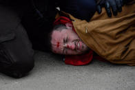 <p>A protester is detained by police in Bismarck during a protest against plans to pass the Dakota Access pipeline near the Standing Rock Indian Reservation, N.D., on Nov. 17, 2016. (Stephanie Keith/Reuters) </p>