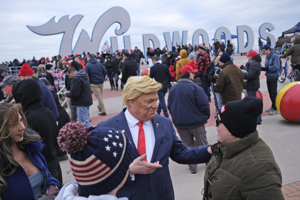 Tim Carney, dressed as President Donald Trump, center, talks with people near the boardwalk before the start of a campaign rally in Wildwood, N.J., Tuesday, Jan. 28, 2020. (AP Photo/Seth Wenig)