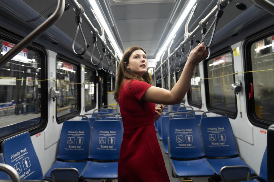 Chicago Transit Authority media representative Maddie Kilgannon talks about the new features inside an electric bus as it charges in the West Side garage Tuesday, Feb. 14, 2023, in Chicago. No. 66 is the first of many routes that will be converted to battery power as the CTA moves to all-electric by 2040. (AP Photo/Erin Hooley)