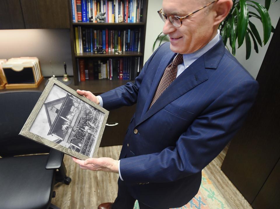 Attorney Tom Tupitza describes a historical family photo, recently sent to him by a cousin and displayed in his office.