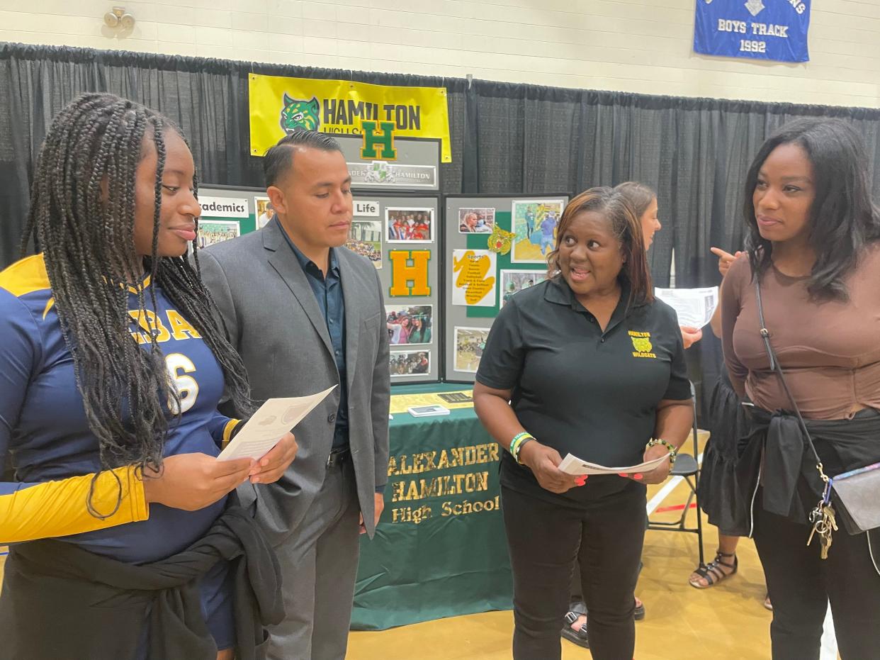 Asinah Gardner, left, and Alexia Knox, right, learn about Hamilton High School from Assistant Principal Francisco Paradones and Parent Coordinator Bridgett Franklin at a MPS enrollment fair Sept. 23.