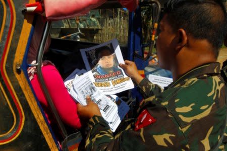 FILE PHOTO: Soldiers distribute pictures of a member of extremist group Abu Sayyaf Isnilon Hapilon, who has a U.S. government bounty of  million for his capture, in Butig, Lanao del Sur in southern Philippines February 1, 2017.  REUTERS/Marconi B. Navales