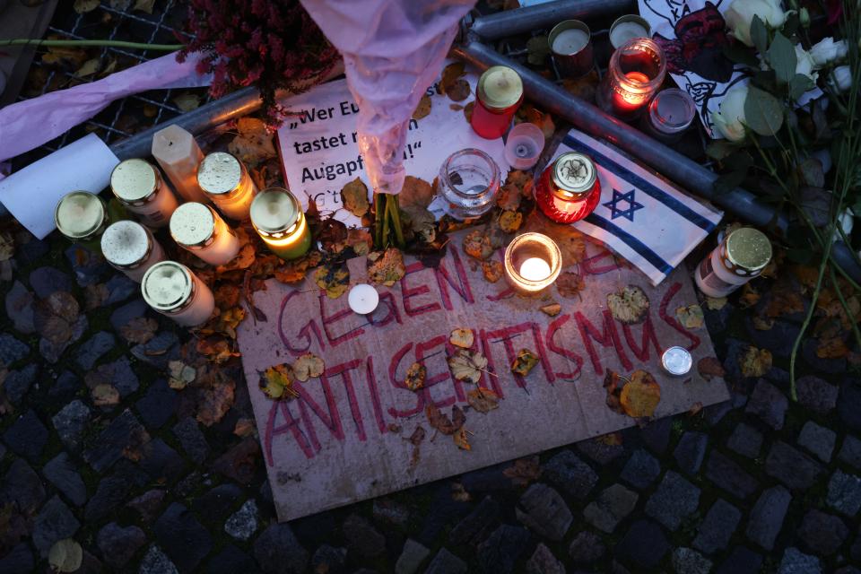 BERLIN, GERMANY - OCTOBER 20: Candles left by participants stand over a sign that reads: "Against Antisemitism" during a vigil outside the Kahal Adass Jisroel Orthodox Jewish community center on October 20, 2023 in Berlin, Germany.