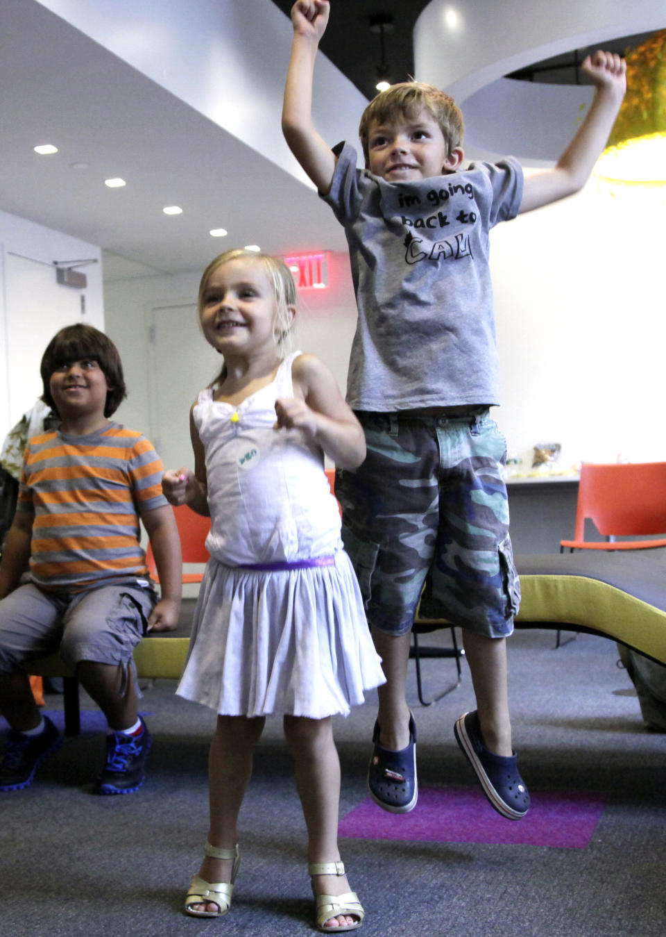 In this Sept. 5, 2012, photo, Aidan Lain, 7, jumps while watching "Kinect Sesame Street TV" at the Sesame Street Workshop in New York. "Kinect Sesame Street TV", launching Tuesday, Sept. 18, 2012, uses Kinect, a motion and voice-sensing controller created by Microsoft, to give Elmo, Big Bird and the rest of the Sesame Street crew a chance to have a real two-way conversation with their pint-sized audience. The effort represents the next step in the evolution of television, adding an interactive element to what's still largely a passive, lean-back experience. (AP Photo/Mark Lennihan)