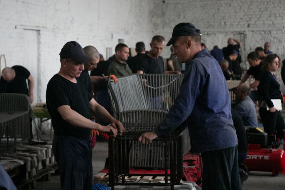 Russian prisoners of war inside one of the workshops crafting garden furniture inside a POW camp in Ukraine in Sept., 2023. (Alexander Khrebet / The Kyiv Independent)