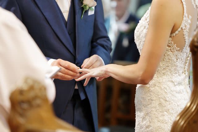 <p>Getty</p> Photo illustration of a groom putting a ring on his bride's finger at their wedding