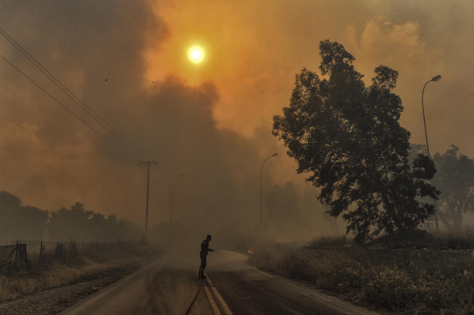 <p>A firefighter tries to extinguish hotspots during a wildfire in Kineta, near Athens, on July 23, 2018. (Photo: Valerie Gache/AFP/Getty Images) </p>