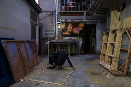 A man makes wooden frames in Dafen Oil Painting Village in Shenzhen, Guangdong province, China December 6, 2018. REUTERS/Thomas Suen