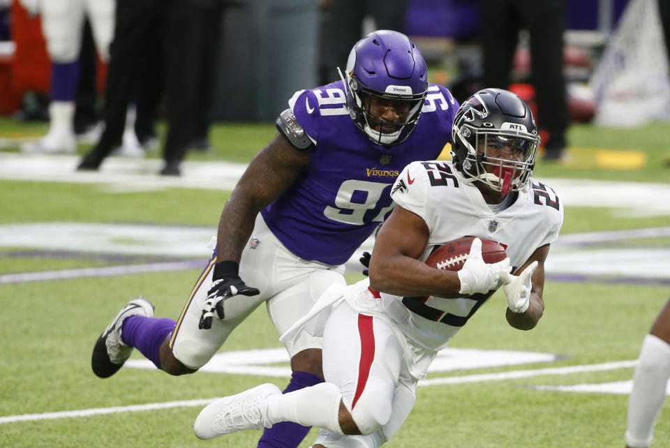 Atlanta Falcons running back Ito Smith (25) runs from Minnesota Vikings defensive end Yannick Ngakoue (91) during the first half of an NFL football game, Sunday, Oct. 18, 2020, in Minneapolis. (AP Photo/Bruce Kluckhohn)