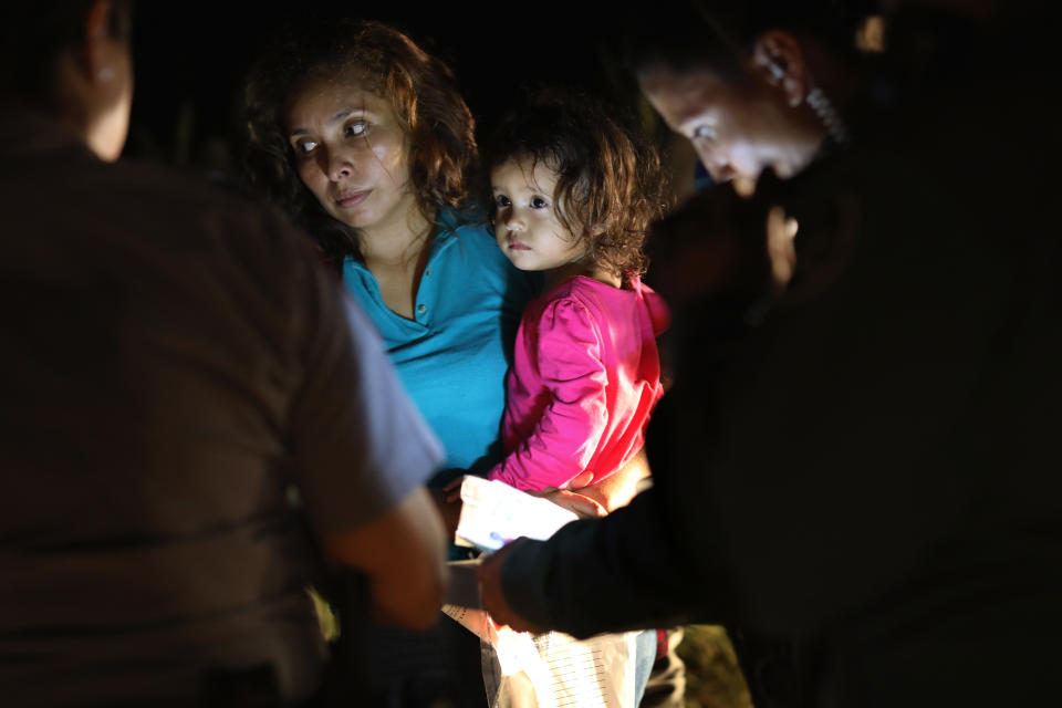 A Honduran mother holds her 2-year-old as U.S. Border Patrol agents review their papers near the U.S.-Mexico border on June 12&nbsp;in McAllen, Texas. (Photo: John Moore via Getty Images)