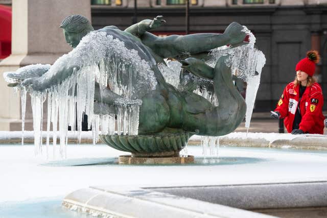 A woman looks at frozen fountains in Trafalgar Square, London