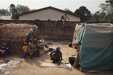 Displaced people sit next to their tents in the grounds of Saint Antoine de Padoue cathedral in Bossangoa, Central African Republic November 25, 2013. REUTERS/Joe Penney