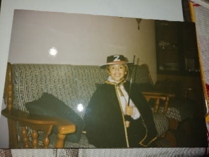 A smiling young child in the Zorro outfit, including a "Z" hat and cape