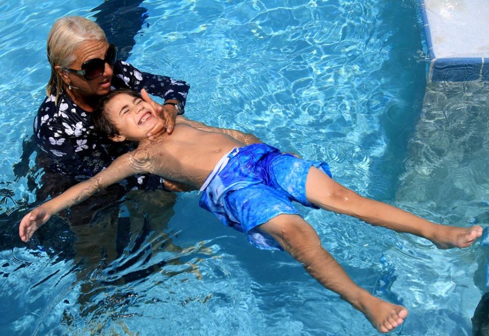 Zachary Esquivel, 5, of Palm Coast, gets instructions from swim instructor Diana Vece at Belle Terre Swim & Racquet Club in Palm Coast Tuesday, June 18, 2013. (Steven Notaras)