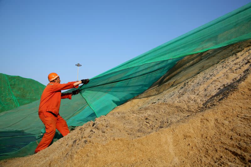 Man works on nickel laterite ore at Ganyu port in Lianyungang