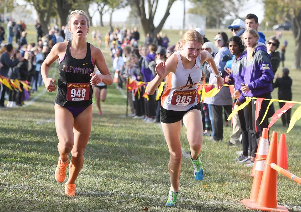 Ames' Payton Stewart and Johnston's Krissy Spear finishes their race during the Class 4A girls state qualifying cross country meet at Pickard Park