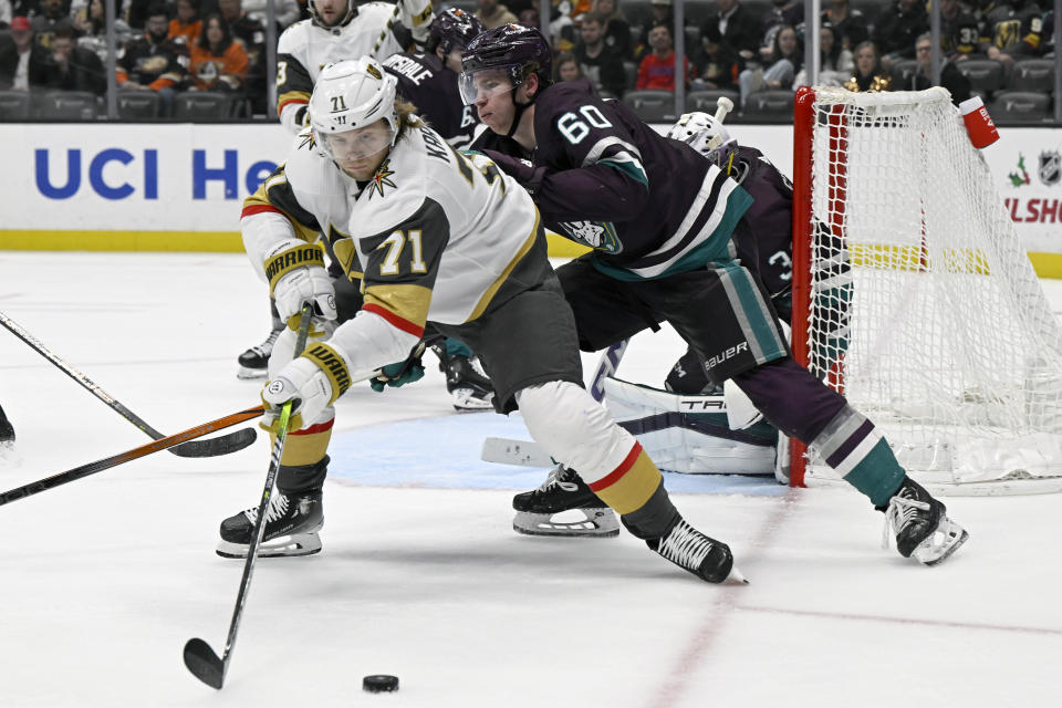 Vegas Golden Knights center William Karlsson (71) controls the puck against Anaheim Ducks defenseman Jackson LaCombe (60) during the third period of an NHL hockey game in Anaheim, Calif., Wednesday, Dec. 27, 2023. (AP Photo/Alex Gallardo)