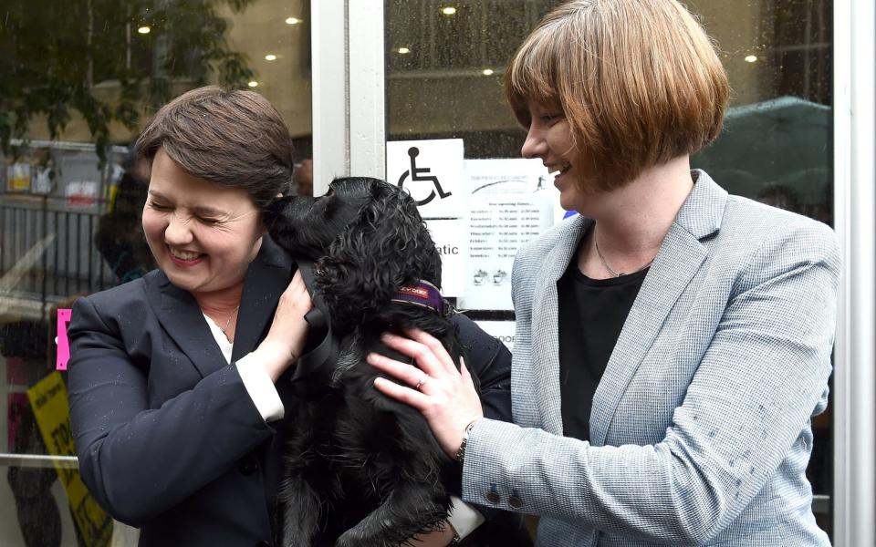 Scottish Conservative leader, Ruth Davidson (L), poses with her partner Jen Wilson and their dog Mister Wilson, at a cafe set up as a Polling Station, in Edinburgh, Scotland - Credit: AFP