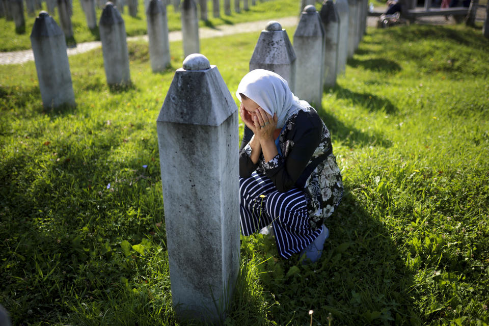 A Bosnian Muslim woman mourns next to the grave of her relative, victim of the Srebrenica genocide, at the Srebrenica Memorial Centre, in Potocari, Bosnia, Thursday, July 11, 2024. Thousands gathered in the eastern Bosnian town of Srebrenica to commemorate the 29th anniversary on Monday of Europe's only acknowledged genocide since World War II. (AP Photo/Armin Durgut)