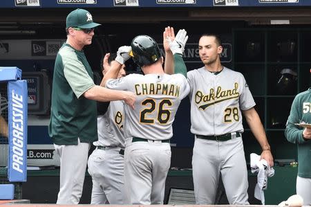 May 22, 2019; Cleveland, OH, USA; Oakland Athletics third baseman Matt Chapman (26) celebrates after scoring with first baseman Matt Olson (28) and manager Bob Melvin (6) during the fourth inning against the Cleveland Indians at Progressive Field. Mandatory Credit: Ken Blaze-USA TODAY Sports