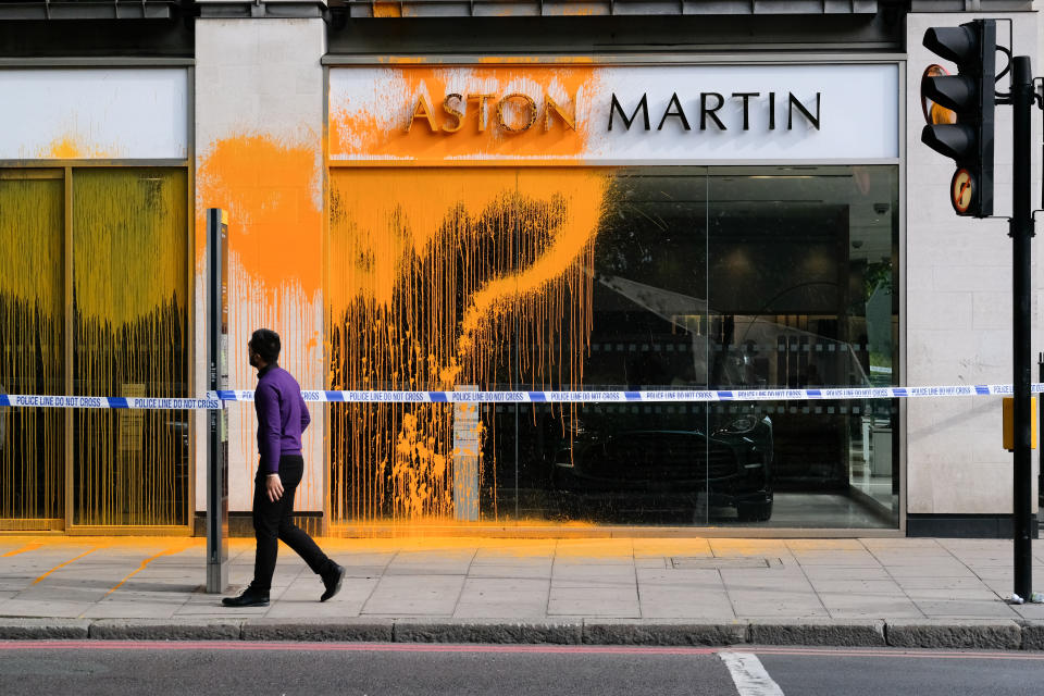 LONDON, UNITED KINGDOM - OCT 16, 2022 - Members of Just Stop Oil spray yellow paint over the Aston Martin dealers on Park Lane. (Photo credit should read Matthew Chattle/Future Publishing via Getty Images)