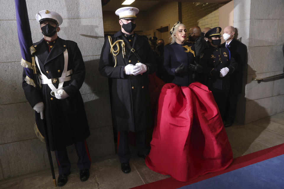 Lady Gaga, flanked by Marine escort Capt. Evan Campbell, arrives to sing the National Anthem for the 59th Presidential Inauguration at the U.S. Capitol for President-elect Joe Biden in Washington, Wednesday, Jan. 20, 2021. (Photo by Win McNamee/Getty Images/Pool Photo via AP)