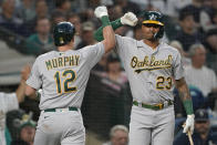 Oakland Athletics' Sean Murphy (12) is congratulated by Christian Bethancourt (23) after Murphy hit a solo home run against the Seattle Mariners during the seventh inning of a baseball game Friday, July 1, 2022, in Seattle. (AP Photo/Ted S. Warren)