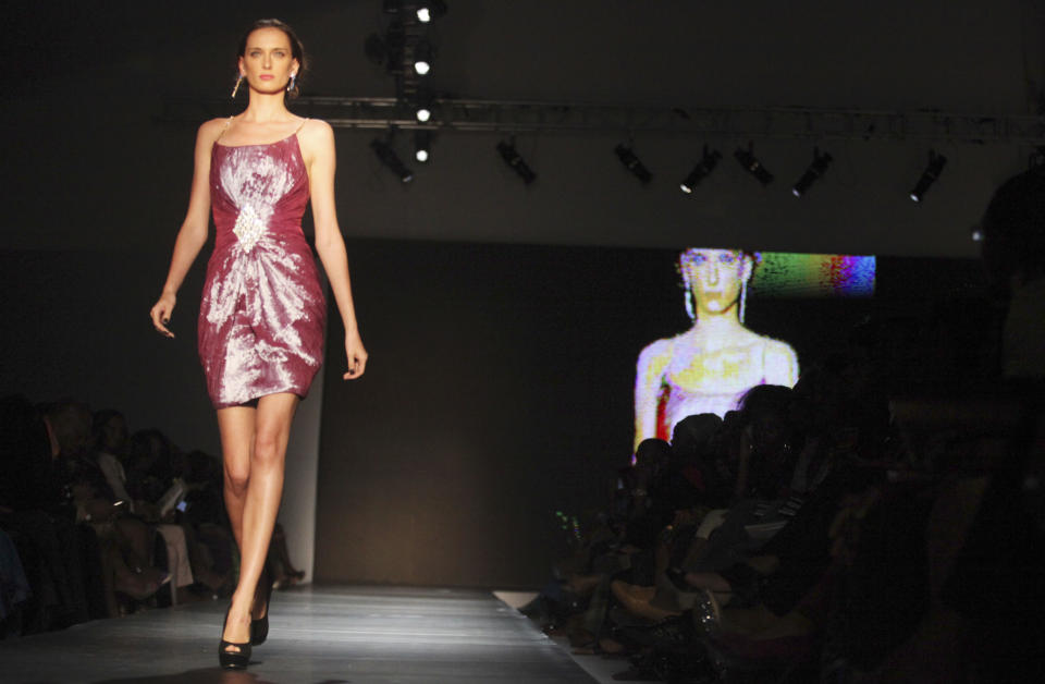 A model displays an outfit at the ARISE Fashion Week event in Lagos, Nigeria on Sunday, March 11, 2012. (AP Photo/Sunday Alamba)