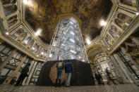 Visitors admire St. John's Baptistery, one of the oldest churches in Florence, central Italy, Tuesday, Feb. 7, 2023. The Baptistery's dome is undergoing a restoration work that will be done from an innovative scaffolding shaped like a giant mushroom that will stand for the next six years in the center of the church, and that will be open to visitors allowing them for the first and perhaps only time, to come come face to face with more than 1,000 square meters of precious mosaics covering the dome. (AP Photo/Andrew Medichini)