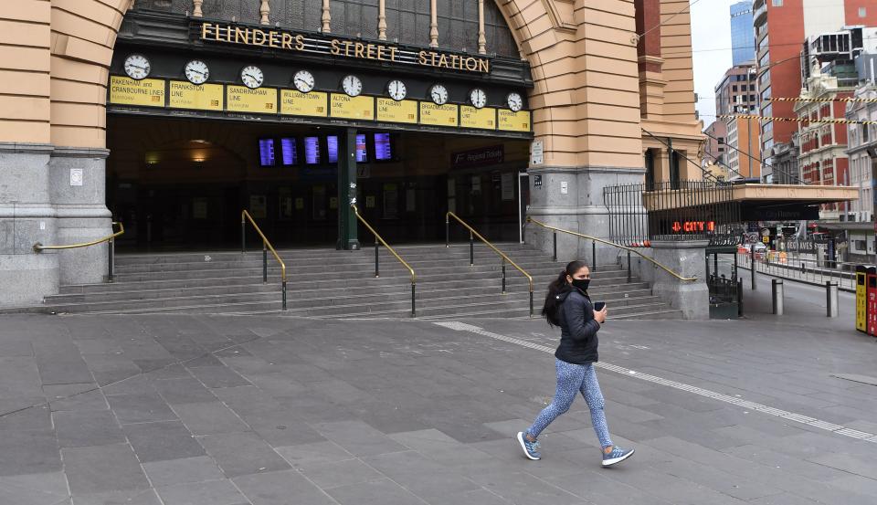 A jogger runs past a near-deserted Flinder Street Station during the morning rush hour in Melbourne on May 28, 2021, as the city's residents returned to a seven day lockdown to curb the spread of the Covid-19 coronavirus. (Photo by William WEST / AFP) (Photo by WILLIAM WEST/AFP via Getty Images)