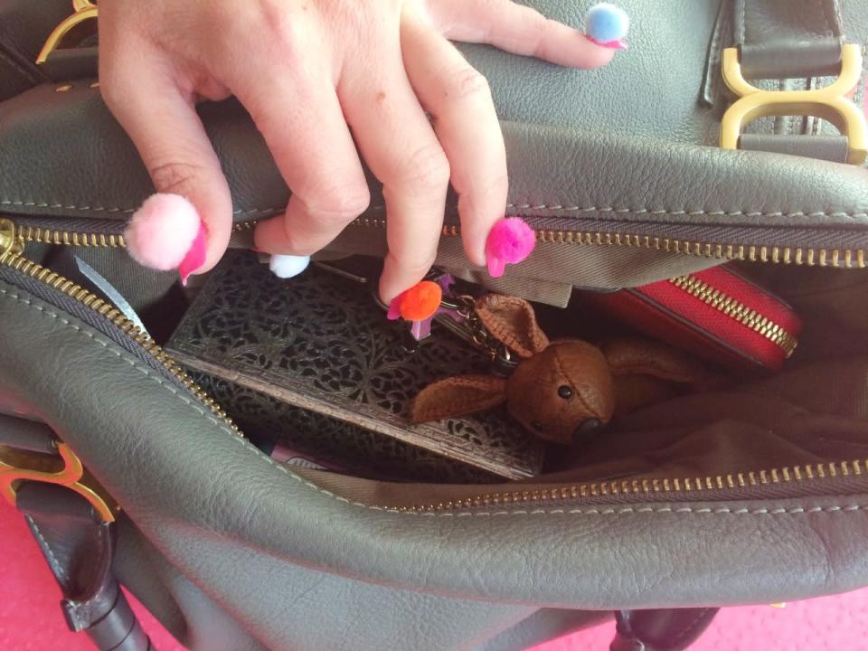 In der Handtasche kramen mit Pom Poms