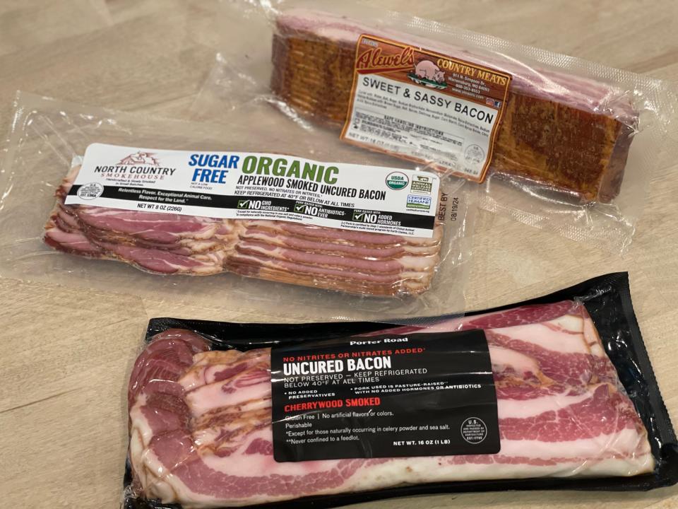 three packs of bacon on a counter