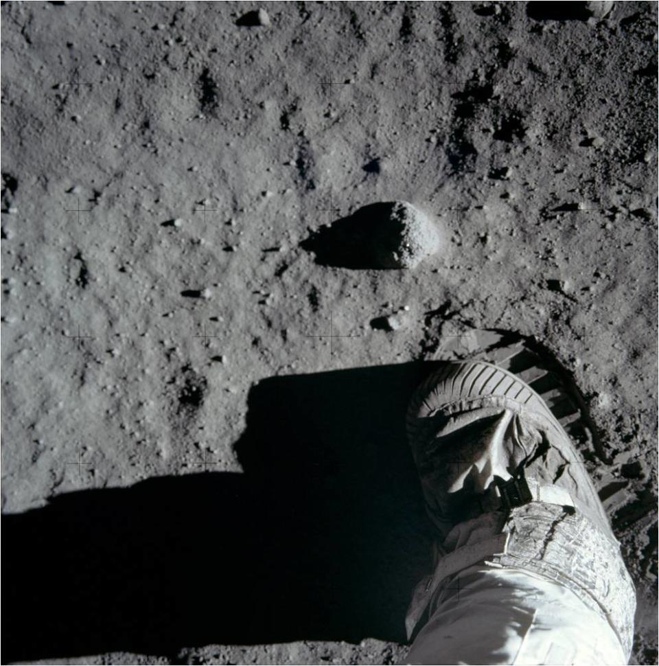 a human foot in a boot on the surface of the moon